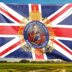 King Charles III flag waving in a field lit by sunlight