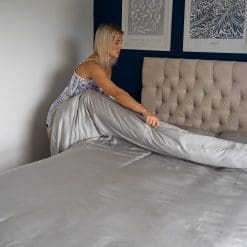 Lady folding her duvet over which is wearing the light grey Bamboo Bedding set