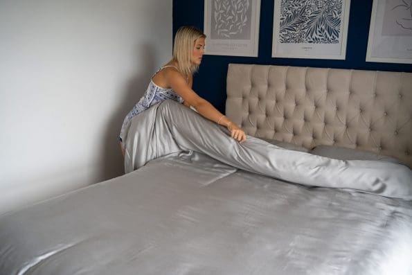Lady folding her duvet over which is wearing the light grey Bamboo Bedding set