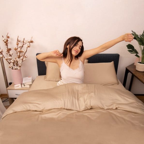 Woman waking up from a relaxing night of sleep in her new Bamboo Bedding set